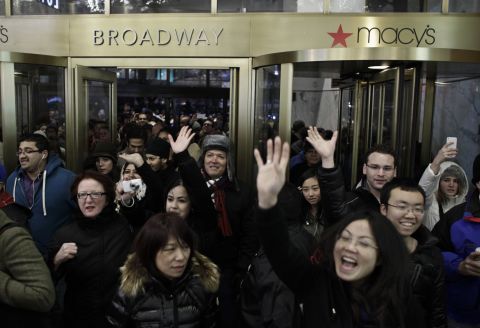 Shoppers enter Macy's as the New York store opens on Thanksgiving Day.