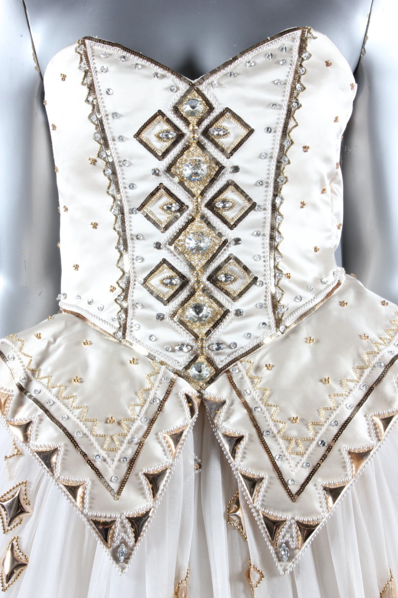 The dress is a dream-like creation made of shimmering white organza, with gold sequins, crystals and pearl beads embedded throughout.