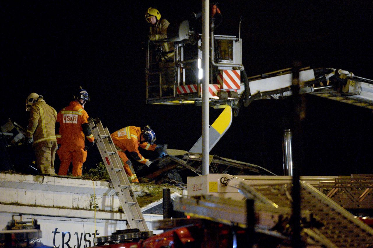 Emergency responders work on the wreckage on top of the pub. 