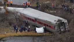 Viewed from Manhattan, first responders and others work at the scene of a  derailed Metro North passenger train in the Bronx borough of New York Dec. 1, 2013. The train derailed on a curved section of track in the Bronx early Sunday, coming to rest just inches from the water, killing at least four people and injuring more than 60, authorities said. Police divers searched the waters to make sure no passenger had been thrown in, as other emergency crews scoured the surrounding woods.