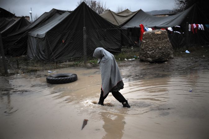 A girl crosses a puddle during the first snowfall of the season in a refugee camp in Harmanli, Bulgaria, on Wednesday, November 27.