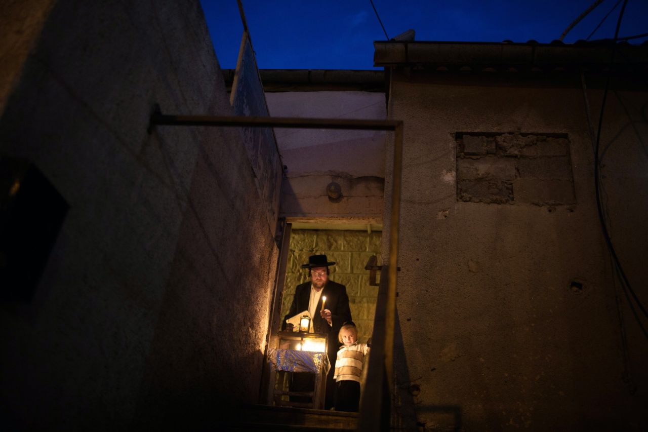 DECEMBER 2 - JERUSALEM: An Ultra-Orthodox Jewish man and his child light candles on the fifth night of the <a href="http://religion.blogs.cnn.com/2013/11/26/giving-thanks-for-the-miracle-of-survival/">Jewish holiday of Hanukkah</a>, the Festival of light. The holiday commemorates the victory of the Maccabees over the Syrians and the re-dedication of the Second Temple of Jerusalem around 165 BC after the Greek King of Syria outlawed Jewish rituals.