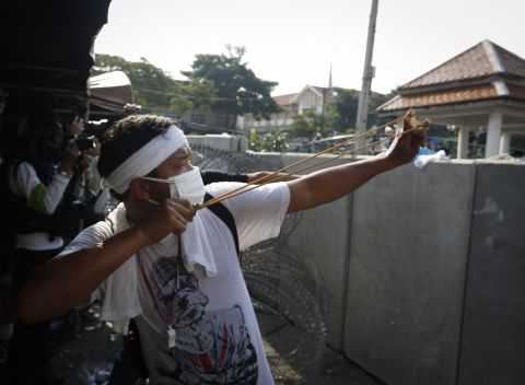 A protester aims a slingshot at riot police December 2 in Bangkok.
