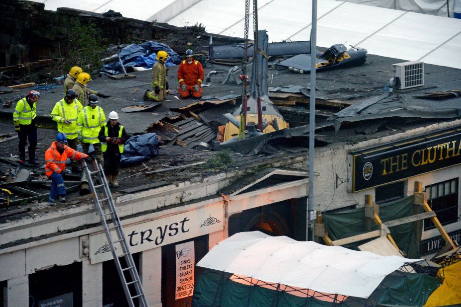 Rescuers work to lift the police helicopter wreckage from the roof of the pub on December 2.