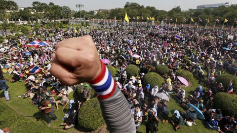 An anti-government protester raises his fist after entering the compound of Government House in Bangkok, Thailand, on Tuesday, December 3. Police removed barricades and allowed demonstrators to enter the government compound as well as the metropolitan police office as part of a truce between protesters and the Thai government for the next few days.