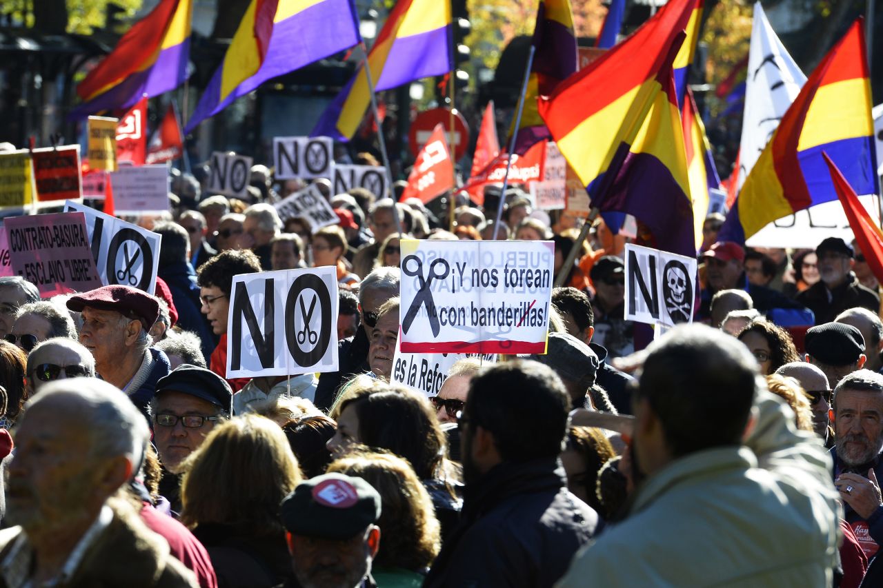 Demonstrators hold placards and flags of the Second Spanish Republic as they take part in a protest against the government's austerity measures in Madrid on November 23, 2013. 