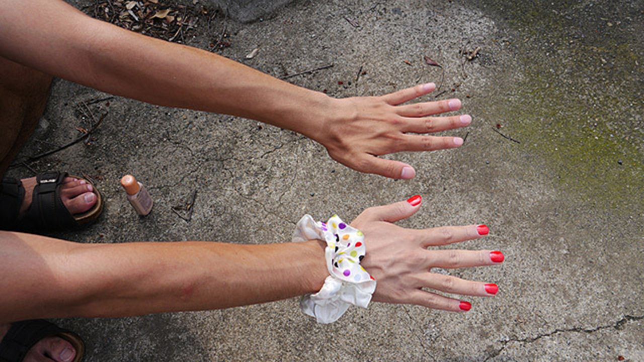 Aplica una base clara en tu mano derecha, y utiliza esmalte de un color encendido para tus uñas, dice Keisuke. Accesorios femeninos como una gruesa coleta en la muñeca mejoran la ilusión.