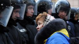 A protester faces riot police on December 3, 2013 as thousands rally outside the Ukrainian parliament in Kiev