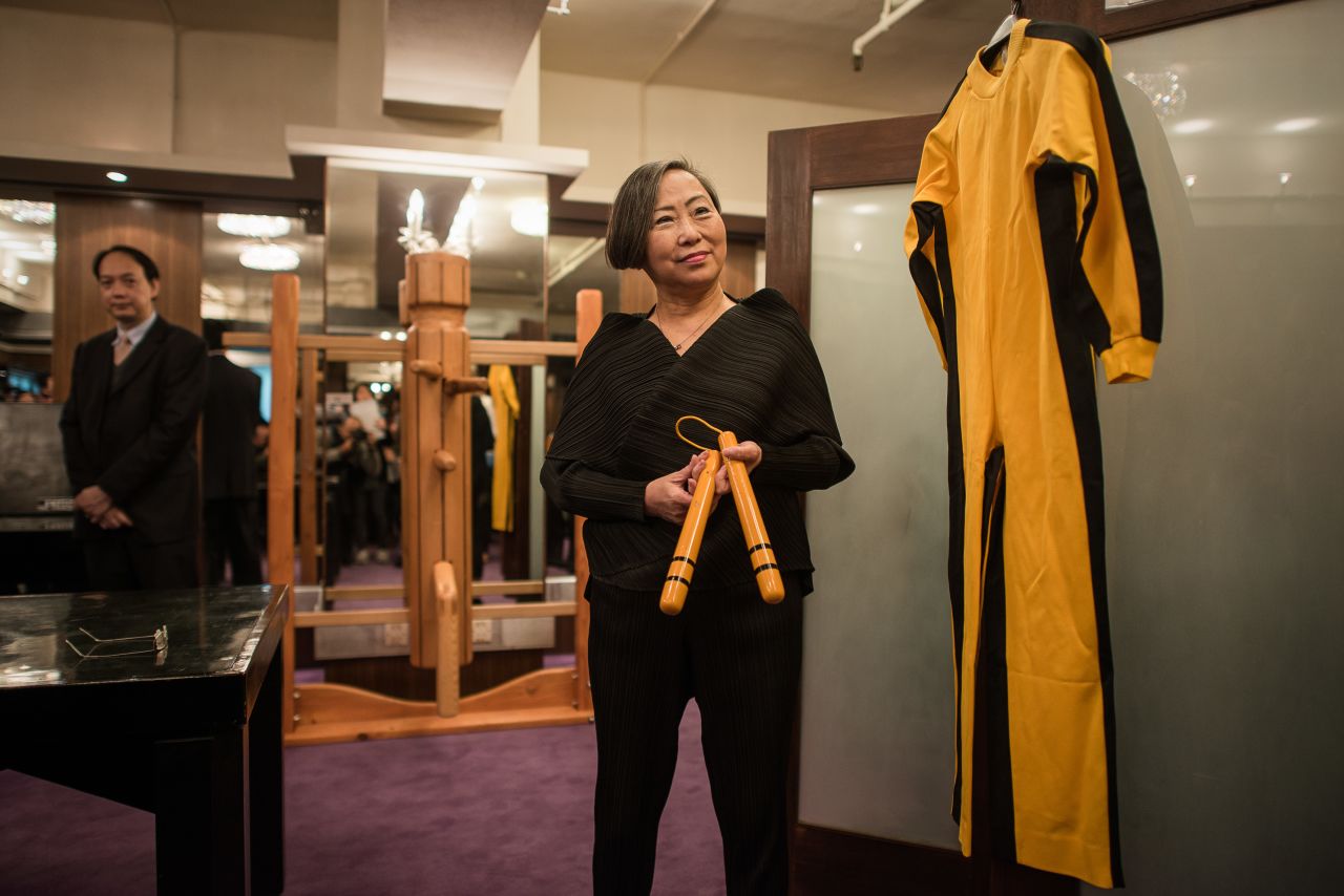 Spink auction house vice chairperson, Anna Lee, presents a yellow and black jumpsuit worn by Bruce Lee and his nunchaku used during the filming of "Game of Death" in 1972.