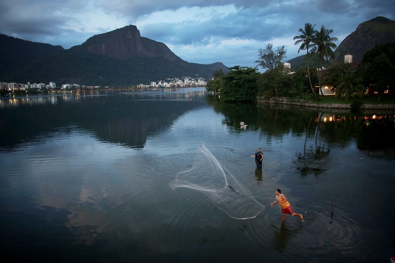 DECEMBER 4 - LAGOA RODRIGO DE FREITAS, BRAZIL: A fisherman tosses his net into Brazil's Lagoa Rodrigo de Freitas, which will host the rowing and canoeing events at the Rio 2016 Olympic Games. In the waters around the future Olympic Park, <a href="http://sportsillustrated.cnn.com/2013/olympics/wires/11/20/2080.ap.oly.rio.2016.dirty.olympics/index.html#ixzz2mVk1jM5a">the average fecal pollution rate is 78 times that of the Brazilian government's ''satisfactory'' limit, </a>but Rio's Olympic committee has pledged in writing that the pollution problems will be fixed as part of the Games' legacy.