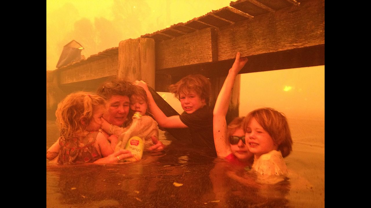 <strong>January 4:</strong> Tammy Holmes and her grandchildren take refuge under a jetty as a wildfire rages nearby in the Tasmanian town of Dunalley, Australia.