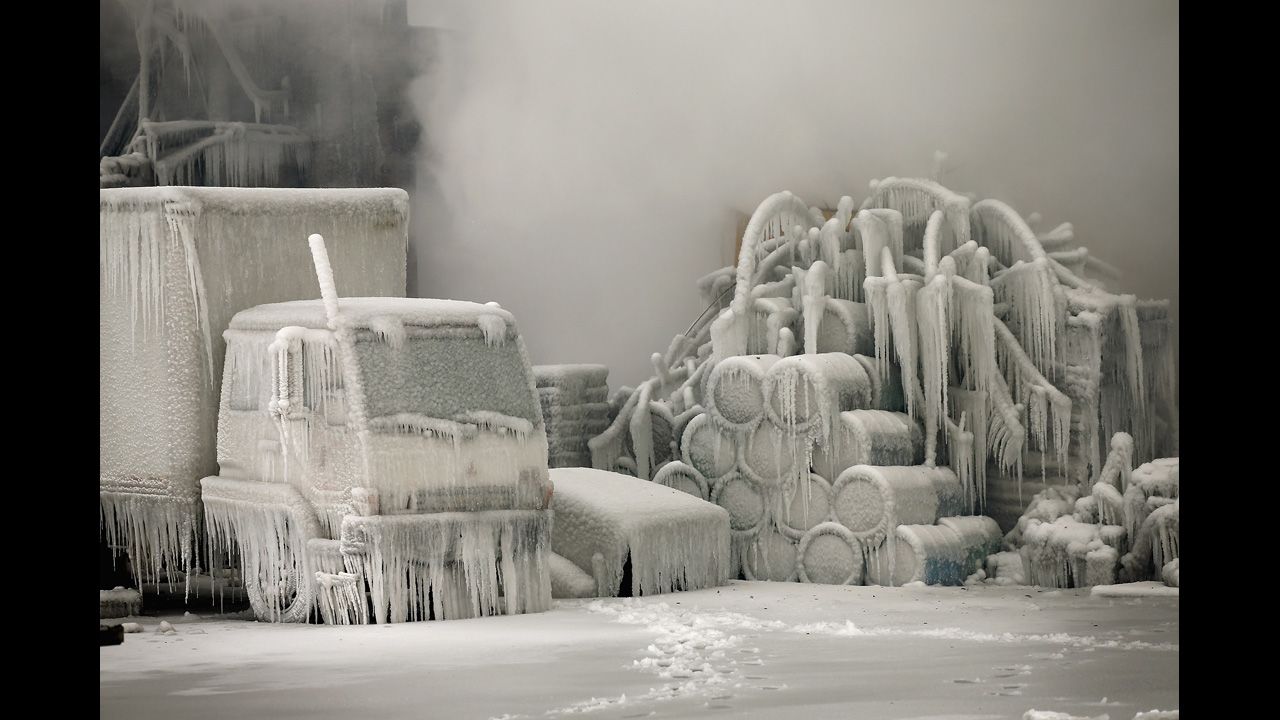 <strong>January 23:</strong> A truck is covered in ice as firefighters extinguish a massive blaze at a vacant warehouse in Chicago.