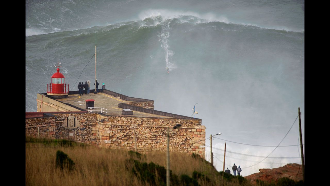 <strong>January 28:</strong> A crowd in Nazare, Portugal, watches as surfing legend Garrett McNamara appears to break his own world record for the biggest wave ever surfed. The wave was estimated to be about 100 feet high.