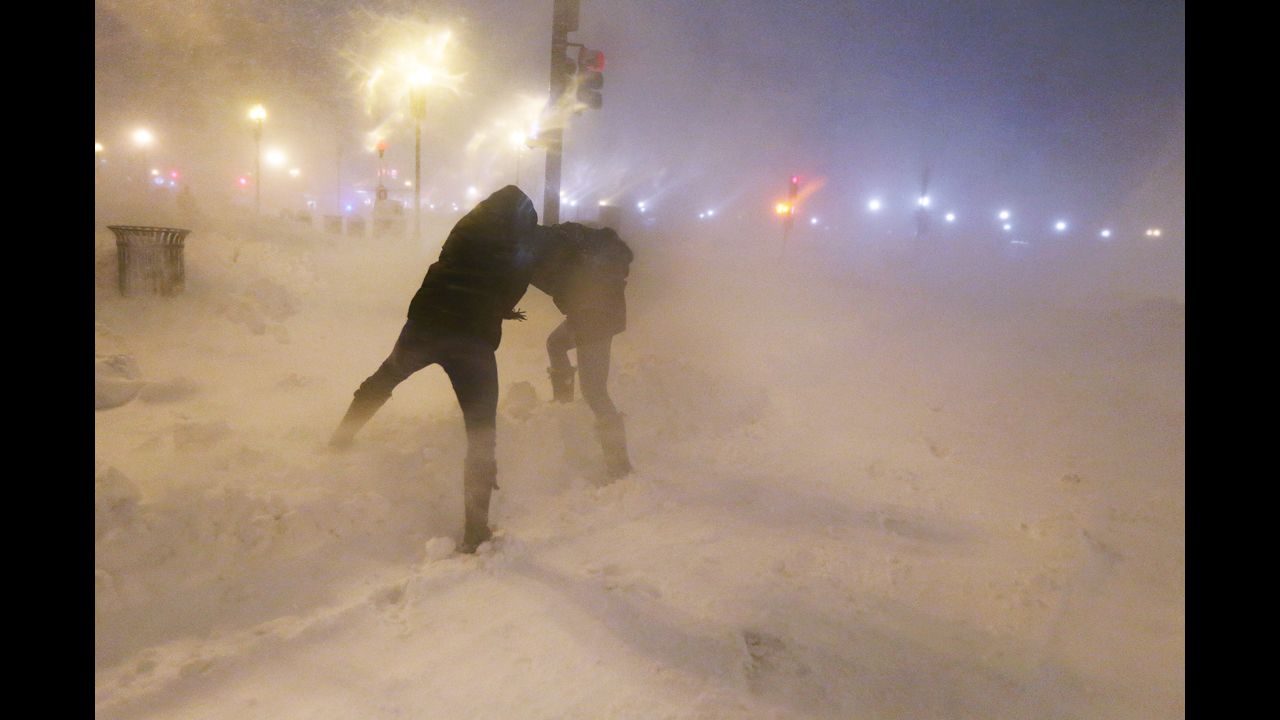 <strong>February 8:</strong> People shield themselves from snow as a blizzard arrives in the Back Bay neighborhood of Boston.