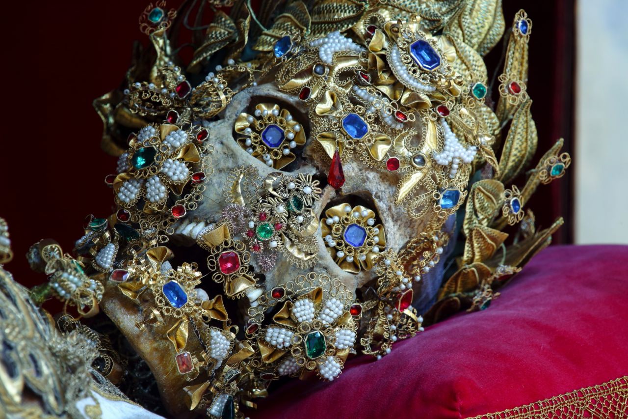 <em>This St. Benedictus was received by the church of St Michael in Munich</em><br /><br /><strong>CNN:</strong> <strong>Many of the catacomb saints have jewels as eyes and gold decorations as smiles. Was there a motivation to make them more human looking?</strong><br /><br /><strong>PK: </strong>The decoration of these skeletons was not like a typical art movement, it was not like a modern movement like cubism or impressionism, where one artist is consciously aware of what others are doing stylistically and you can trace an evolution. There was no uniform style to the decoration of the skeletons, and there were marked regional variants.<br />One of those involved an attempt in some areas to humanize them by molding wax over the skull to give them fake faces, then glass eyes, wigs, and so on. The idea was that by making them "more human" looking, people would be able to achieve a more intimate bond with them. In other words, to make them seem less creepy.