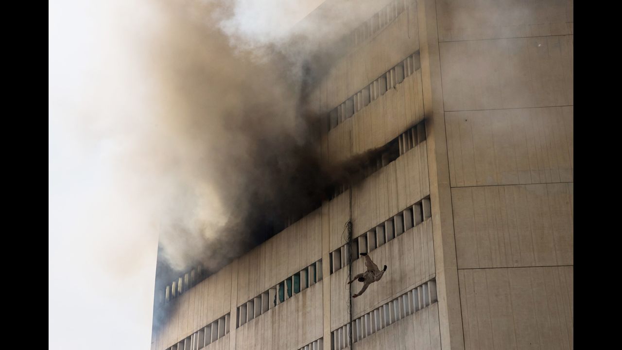 <strong>May 9:</strong> A man overcome by fumes falls out of a window as a fire burns at the Lahore Development Authority Plaza in Lahore, Pakistan.