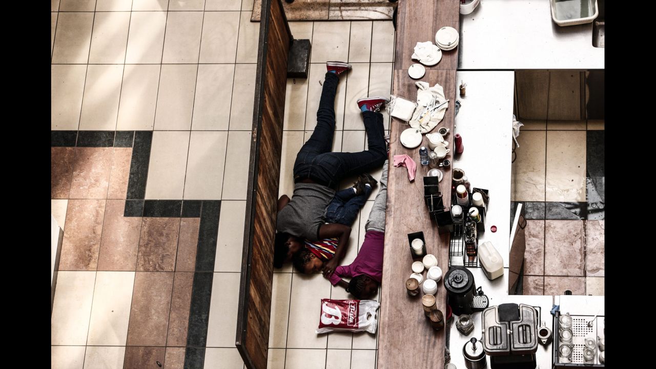 <strong>September 21:</strong> People take cover behind a counter at the Westgate shopping mall after a shootout in Nairobi, Kenya. The Somali terror group Al-Shabaab, an affiliate of al Qaeda, claimed responsibility for a bloody four-day siege at the upscale mall. At least 67 people were killed.