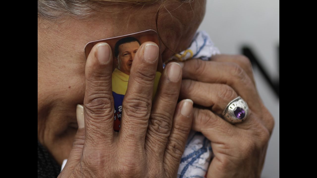 <strong>March 6:</strong> A crying woman holds a picture of Venezuelan President Hugo Chavez outside the military hospital where he died one day earlier in Caracas, Venezuela. Chavez, who had battled cancer, was 58.