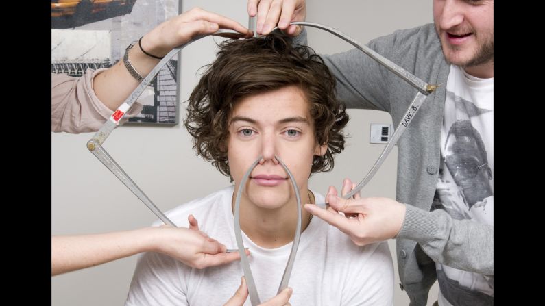 <strong>March 11:</strong> Harry Styles of the boy band One Direction poses with calipers as he is measured for a wax figure by Madame Tussauds.