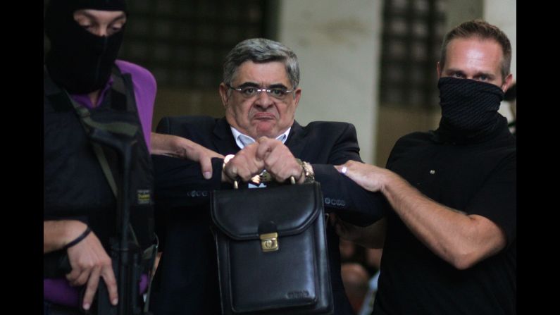 <strong>September 28:</strong> Nikos Michaloliakos, leader of the extreme-right Golden Dawn party, is escorted from police headquarters in Athens, Greece. He faces charges of running a criminal organization following the slaying of an anti-fascist musician.