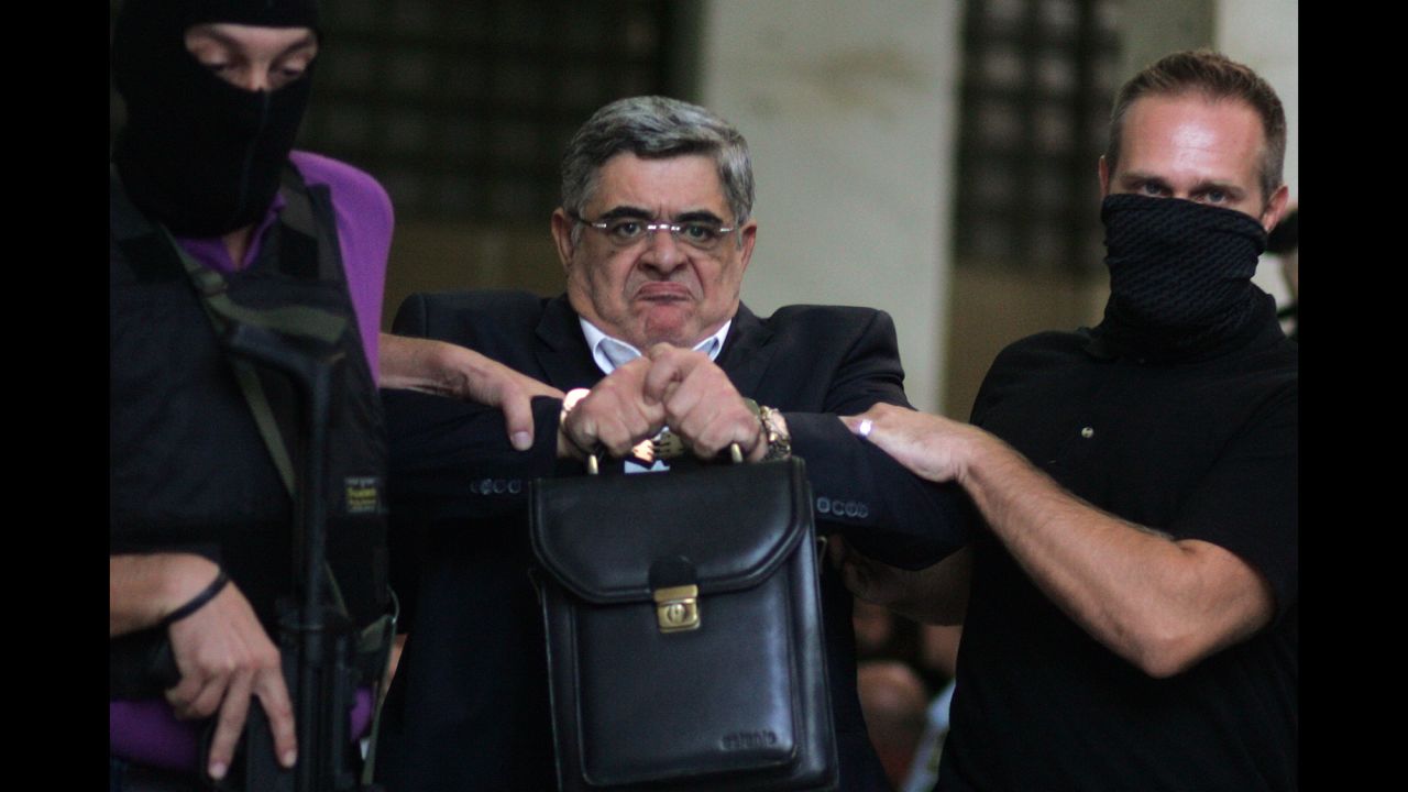 <strong>September 28:</strong> Nikos Michaloliakos, leader of the extreme-right Golden Dawn party, is escorted from police headquarters in Athens, Greece. He faces charges of running a criminal organization following the slaying of an anti-fascist musician.