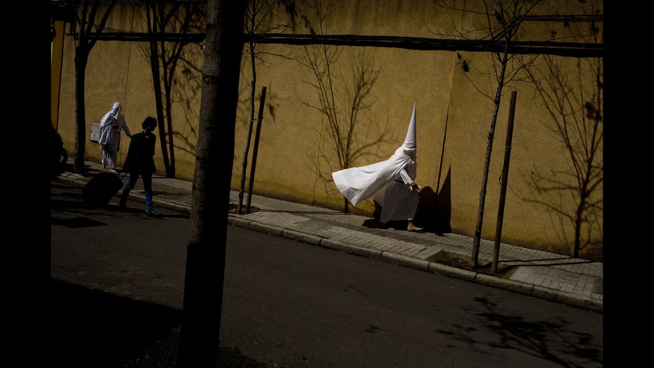 <strong>March 24:</strong> Hooded penitents from the La Paz brotherhood walk to a church in Seville, Spain, to take part in a procession during Easter Holy Week.