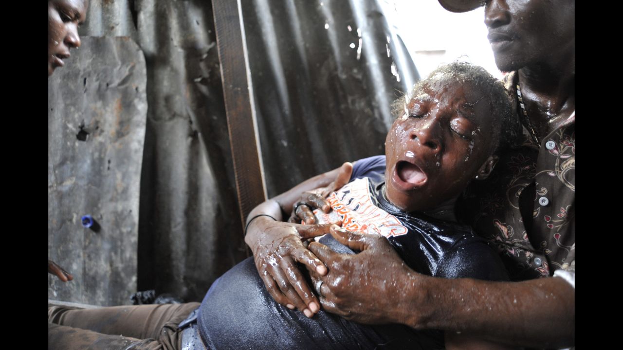 <strong>September 30:</strong> A woman in Port-au-Prince, Haiti, suffers an asthma attack after tear gas was used during an anti-government demonstration on the anniversary of the 1991 coup against former President Jean-Bertrand Aristide.