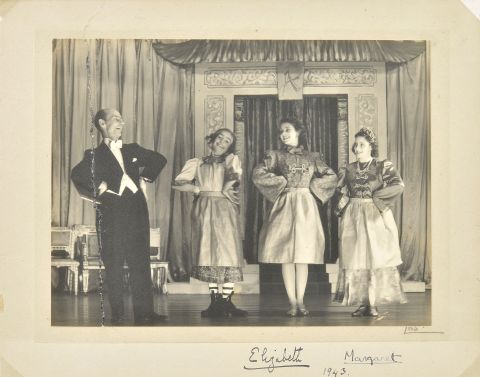 Princess Elizabeth (3R) and Princess Margaret (4R) on stage in a photograph signed in 1943.