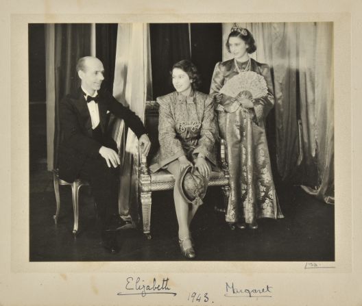 Princess Elizabeth (C) and Princess Margaret (R) on stage in a photograph signed in 1943.