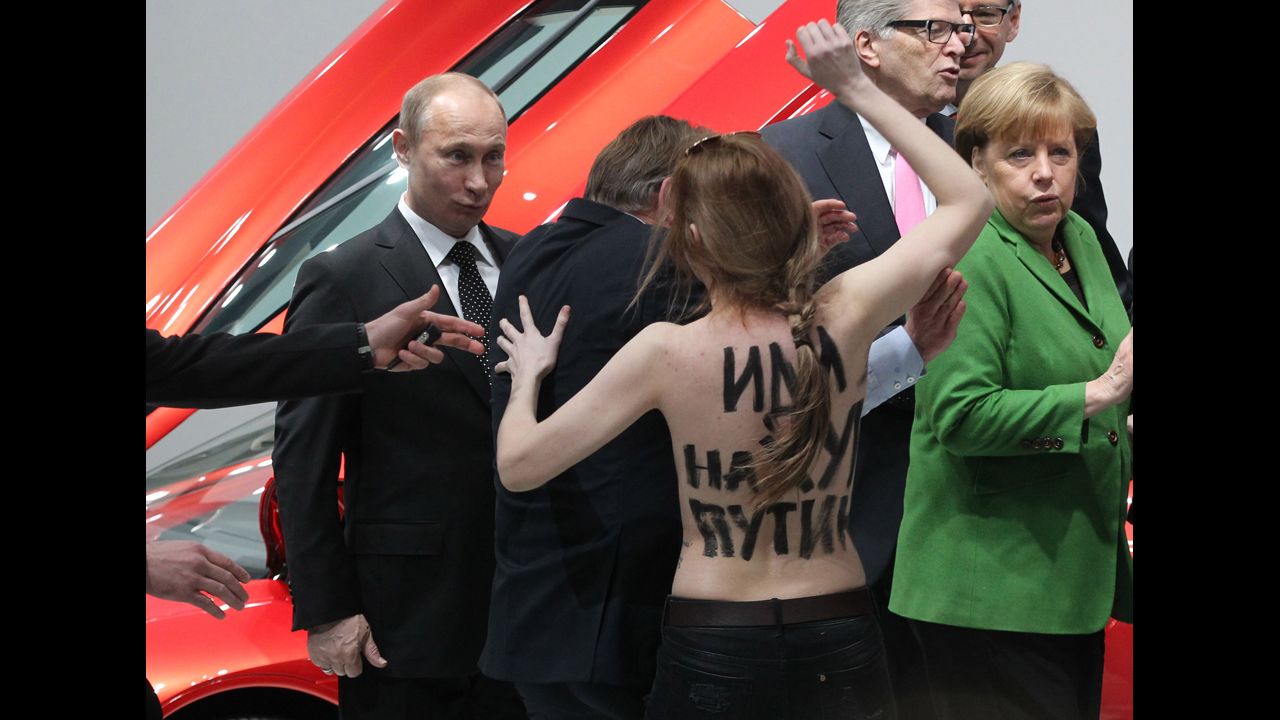 <strong>April 8:</strong> Russian President Vladimir Putin is attacked by an activist of the Ukrainian women rights group Femen as German Chancellor Angela Merkel looks on in Hannover, Germany.