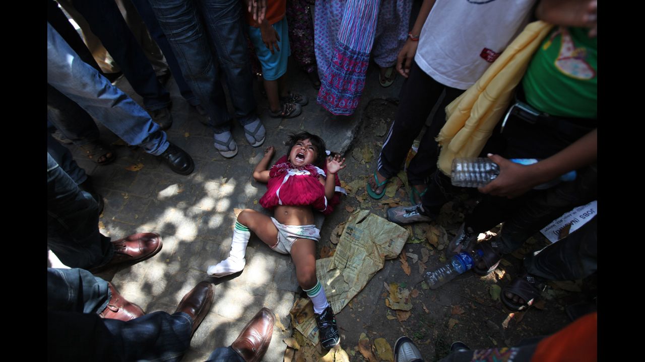 <strong>April 17:</strong> Outside the United Nations office in New Delhi, India, a young girl from Pakistan cries after being flung on the ground by her mother during a protest against alleged human rights violations in Pakistan.