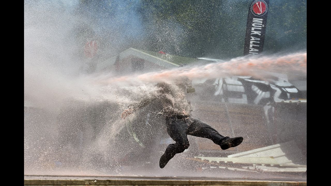 <strong>June 11:</strong> A protester is hit by a water cannon during clashes in Taksim Square in Istanbul.