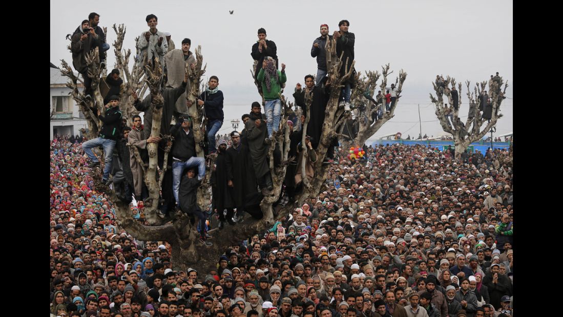 <strong>February 1:</strong> Kashmiri Muslims stand on a tree as they offer prayers at the Hazratbal Shrine in Srinagar, India.