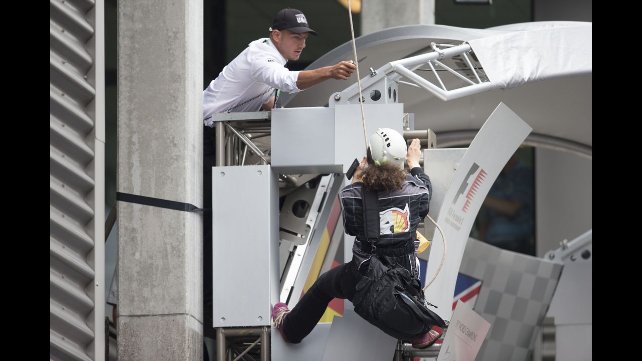 <strong>August 25:</strong> A man threatens to cut the rope of a Greenpeace protester at the Belgian Grand Prix in Spa, Belgium.