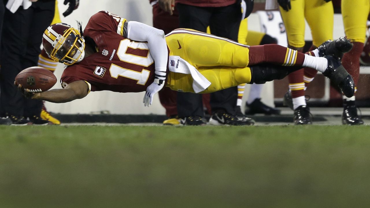 Washington Redskins quarterback Robert Griffin III dives on a quarterback keeper during the first half of an NFL wild card playoff game against the Seattle Seahawks on January 6 in Landover, Maryland. The Seahawks won 24-14.