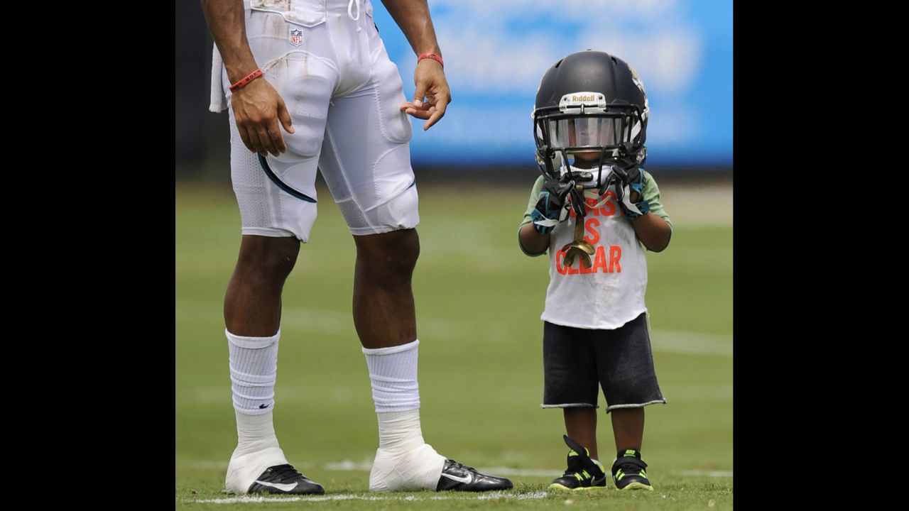 Two-year-old Cecil Shorts IV wears the helmet of his father, Jacksonville Jaguars wide receiver Cecil Shorts III, during NFL training camp on July 31 in Jacksonville, Florida.
