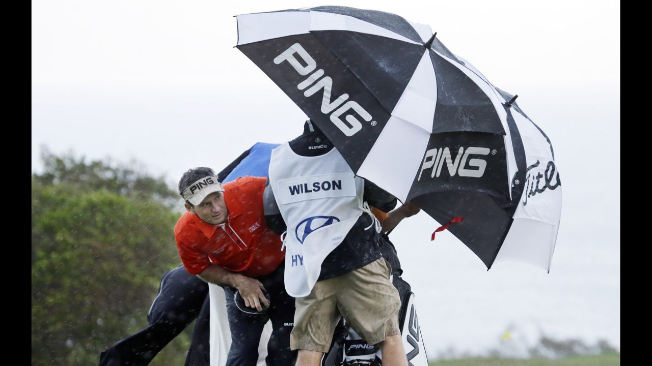 Mark Wilson peers out from under an umbrella as he waits for a rainsquall to ease up before teeing off on the 10th hole during the first round of the PGA Tournament of Champions on January 7 in Kapalua, Hawaii. Play was supposed to start three days earlier but was delayed because of rain and high winds.