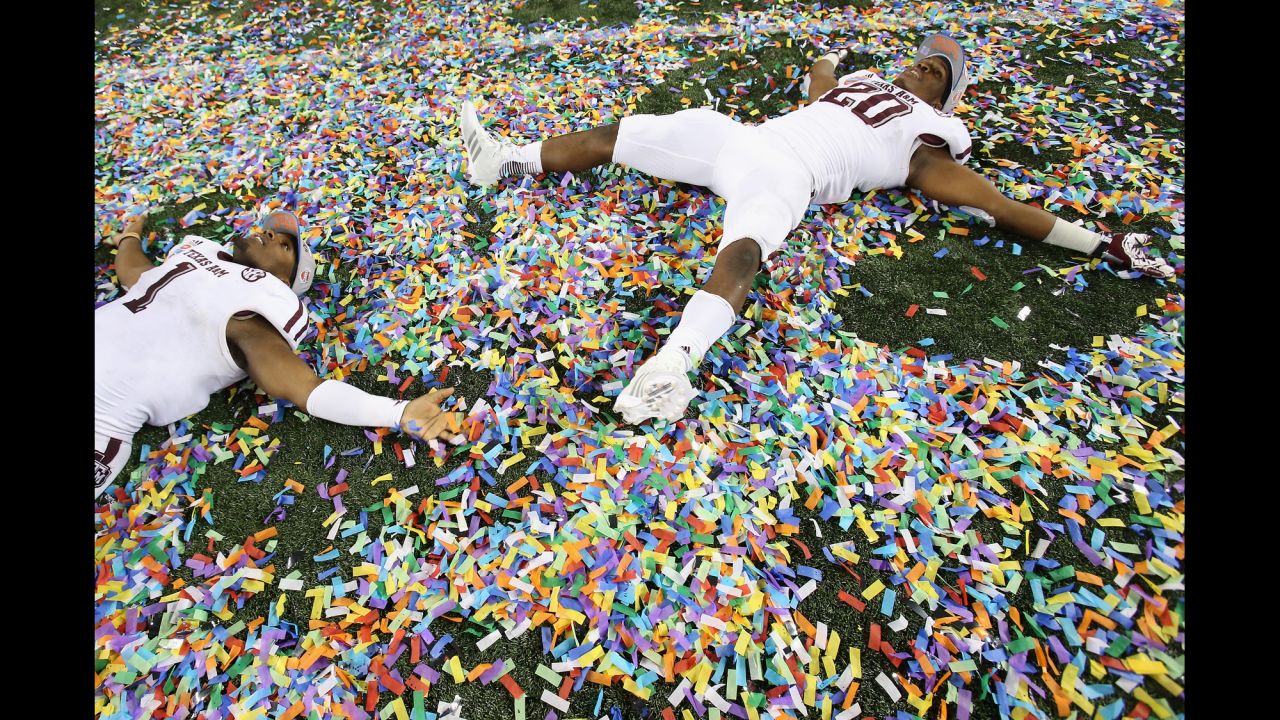 Ben Malena, left, and Trey Williams of the Texas A&M Aggies make angels in the confetti after a 41-13 win against the Oklahoma Sooners during the Cotton Bowl on January 4 at Cowboys Stadium in Arlington, Texas.