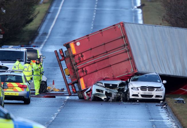 Police work at the scene where a semi-truck was blown onto other vehicles in West Lothian, Scotland, on December 5. The truck driver was killed in the accident.