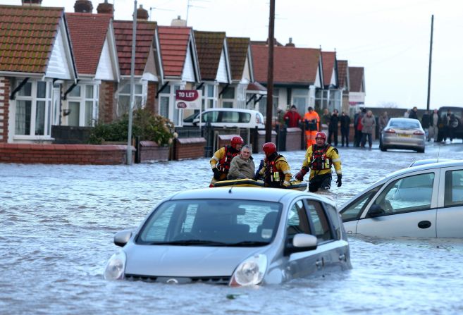 A rescue team helps a man across floodwaters in Rhyl on December 5.