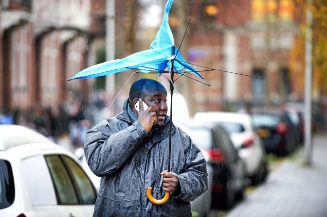 A man walks with a broken umbrella December 5 in Utrecht, Netherlands.