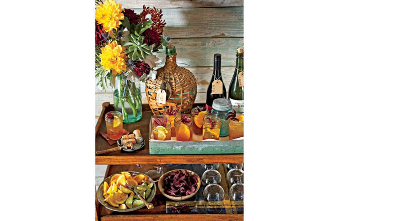 A simple wood bar cart has plenty of room for prepared drinks, garnishes, extra glasses and bottles of wine.