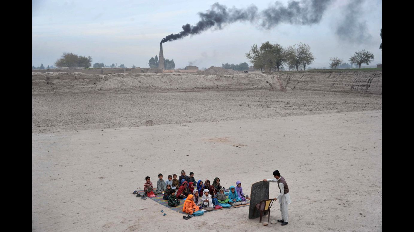 <strong>December 1:</strong> Schoolchildren take lessons at a refugee camp on the outskirts of Jalalabad, Afghanistan.