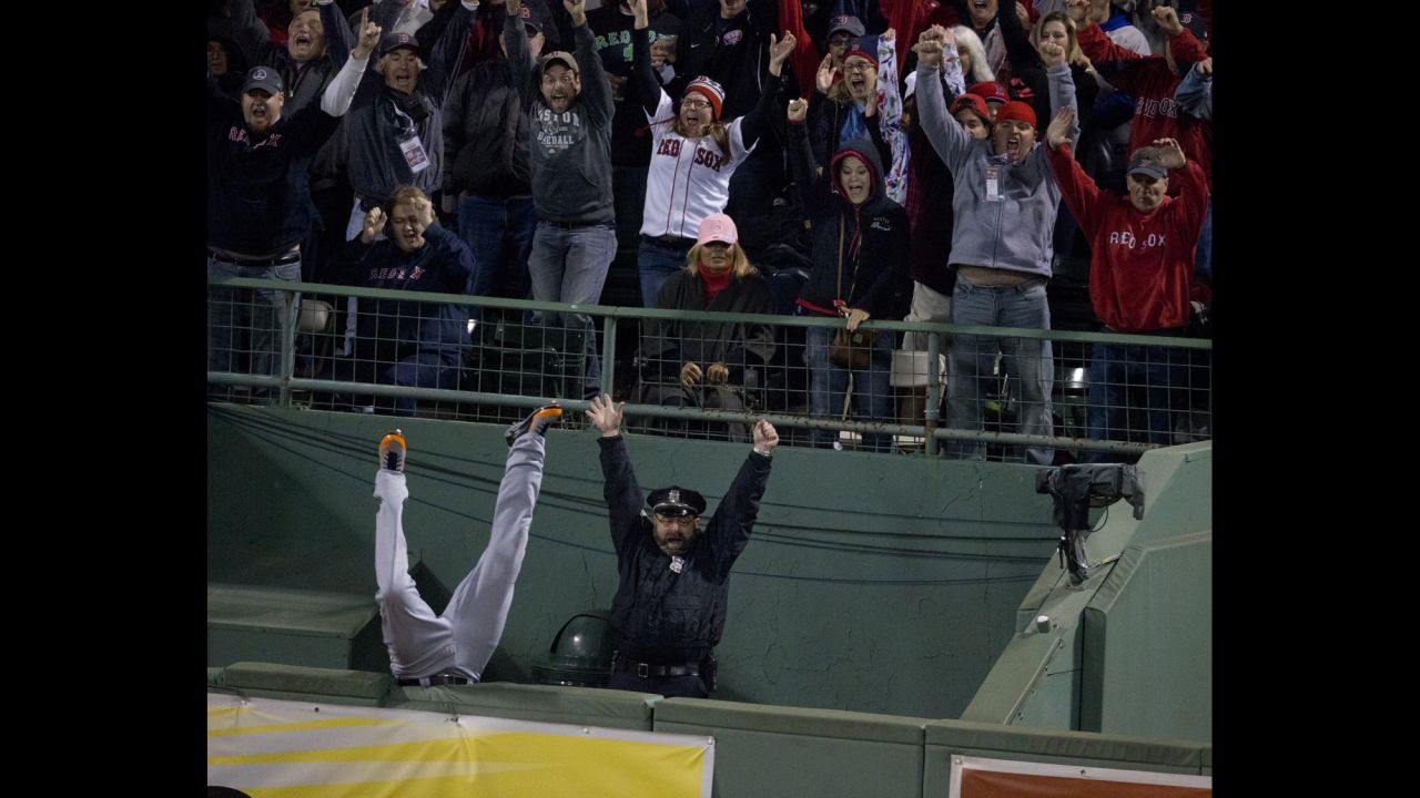 Torii Hunter of the Detroit Tigers falls into the bullpen while trying to catch a homerun ball hit by David Ortiz of the Boston Red Sox to tie the game in the eighth inning at Fenway Park in Boston on October 13. The Red Sox defeated the Tigers 6-5 in Game 2 of the American League Championship Series.