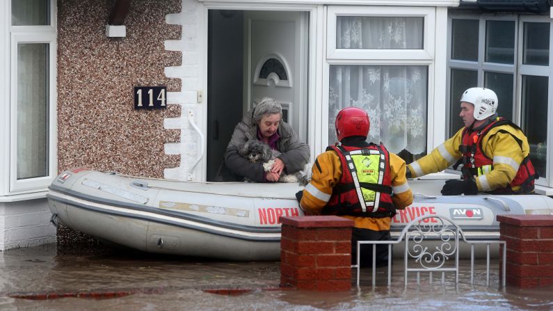 Members of the Royal National Lifeboat Institute rescue a woman and her dog from floodwaters in Rhyl, Wales, on December 5.