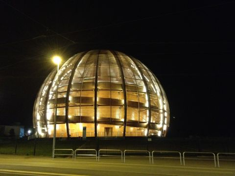The Large Hadron Collider is located at CERN, the European Organization for Nuclear Research, near Geneva, Switzerland. This is CERN's Globe of Science and Innovation, which hosts a small museum about particle physics inside. The ATLAS experiment, which also detected the Higgs boson, is housed underground nearby. 