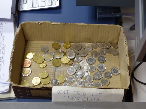 "Don't feed the physicists" marks a box of coins where CMS scientists deposit change to pay for coffee. 