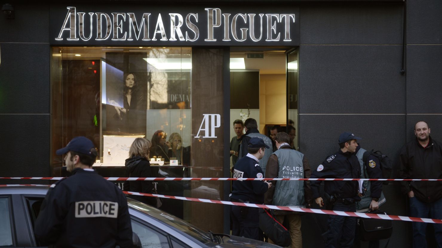 French policemen stand guard in front of a jewellery store that was attacked on December 5, 2013, in Paris.