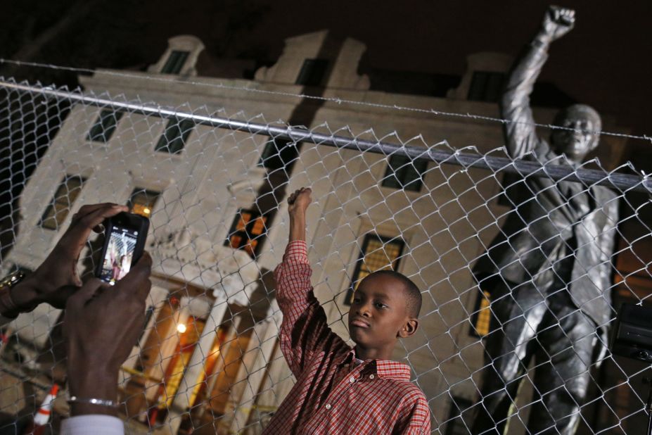 Keaton Anderson, 10, poses for a photograph while he and his father visit Mandela's statue at the South African Embassy in Washington on December 5. The statue is under renovation.