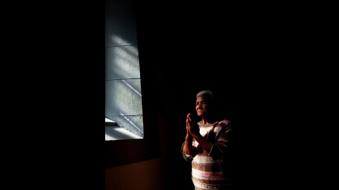 A woman prays at the Central Methodist Church as people remember Mandela on Friday, December 6, in Cape Town, South Africa.  